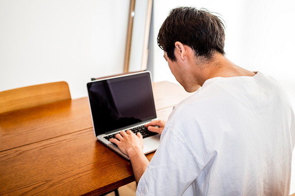 前かがみの不良姿勢でパソコン作業をする男性